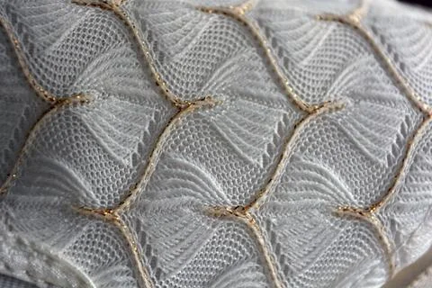 White woven fabric with an pattern of white and fine gold threads. Foto stock
