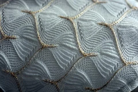 White woven fabric with an pattern of white and fine gold threads. Foto stock