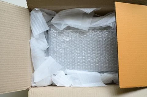 White wrap bubble put in brown box 스톡 사진