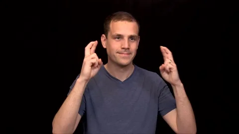 A white young Man on black background crosses his fingers hopeful Vidéo 146263699