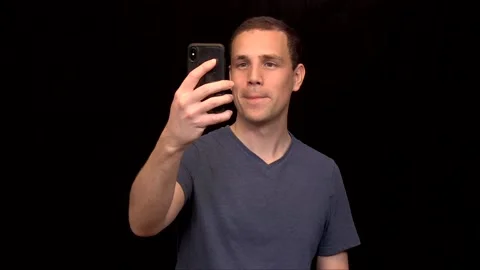 A white young Man on black background takes a selfie with thumb up Vidéo 146263733