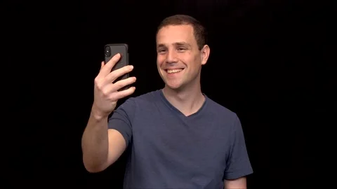 A white young Man on black background is on a video call happy Vidéo 146263784