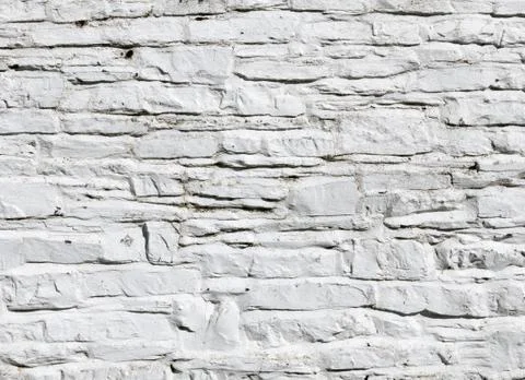 Whitewashed paint on stone wall close up. Stock Photos
