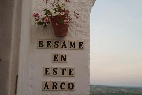 Whitewashed wall with the Spanish expression besame en este arco Stock Photos