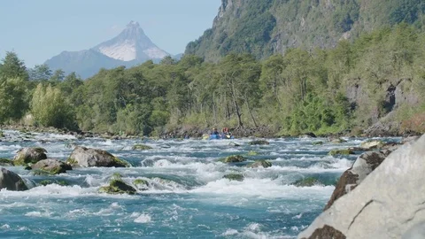 Whitewater rafters on a river in front of a volcano. Rapids in Patagonia 스톡 동영상 70453816