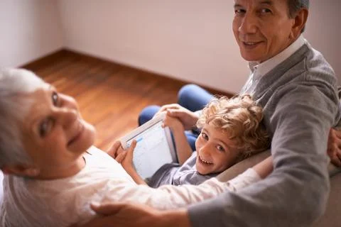 Who needs tech support when you have grandchildren. A little boy using a tablet Stock Photos