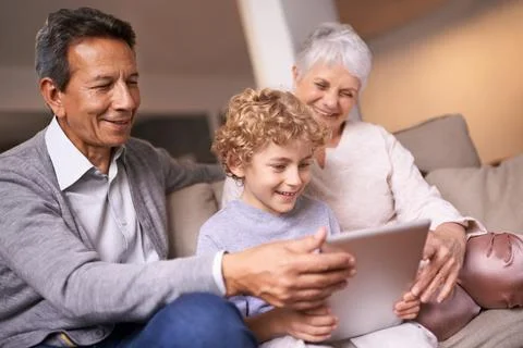 Who needs tech support when you have grandchildren. A little boy using a tablet Stock Photos