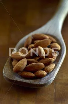 Whole Almonds In A Wooden Spoon