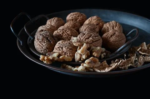 Whole and open raw walnuts on black background Stock Photos