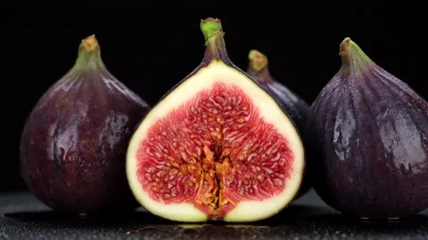 Whole and slice figs. Figs isolated on black background, rotation Stock Footage 161325378