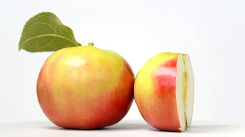 Whole apple and half rotating on white background Stock Footage 111955002
