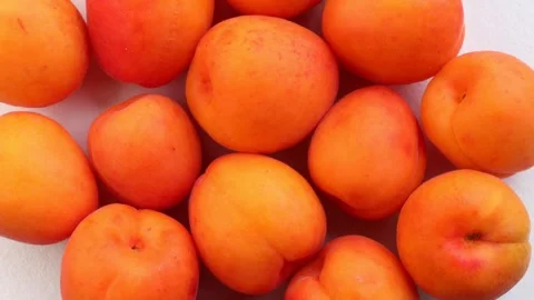 Whole apricots rotating in circle showcasing smooth skin and vibrant color Stock Footage 310337986