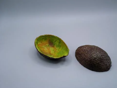 Whole avocado and empty half isolated Stock Photos