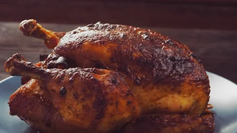 Whole baked chicken carcass with a crispy crust in a soy sauce plate rotates in  Vidéo 218200324