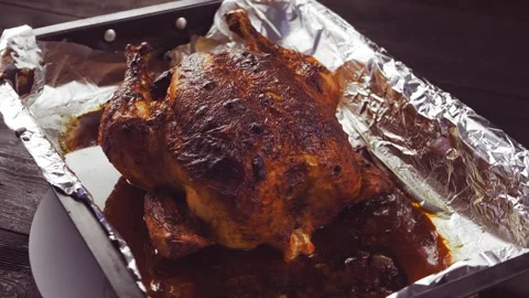 A whole baked chicken carcass with a crispy crust in soy sauce foil on a baking  库存影片 220168827