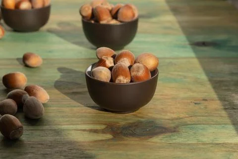 A whole beautiful in-shell hazelnuts in a small ceramic bowl of chocolate col 스톡 사진