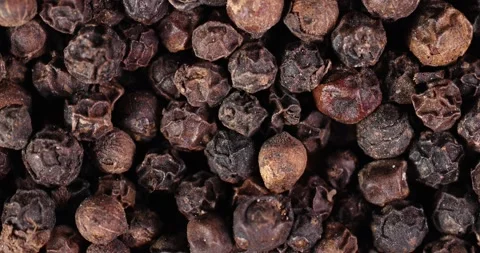 Whole black pepper corn closeup macro on white background motion rotate Stock Footage 159459108