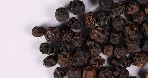 Whole black pepper corn closeup macro on white background motion rotate Stock Footage 159459189