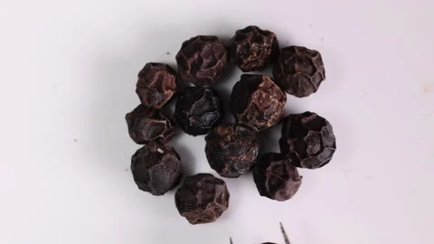 Whole black pepper corn closeup macro on white background motion place using twe Stock Footage 159459268