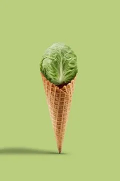Whole cabbage in wafer cone over light green background. Healthy nutrition, food Stock Photos