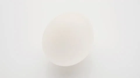 Whole chicken egg in white shell turn on... | Stock Video | Pond5