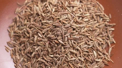 Whole cumin seeds falling onto a pile Video stock 336077216