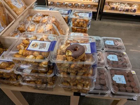 Whole donut with bite missing left on grocery bakery aisle in Brookings, Oregon Stock Photos