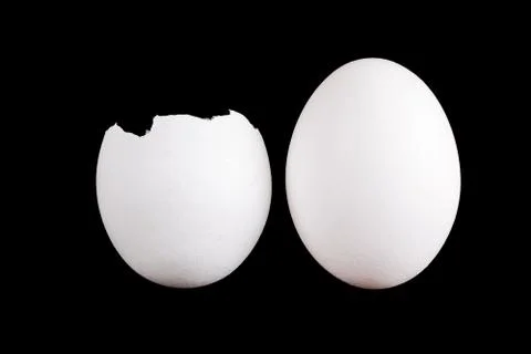 Whole egg and empty eggshell isolated on black background Stock Photos