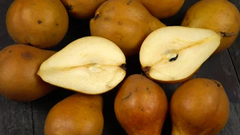 Whole fresh Bosc pears and halved of pear are on a wooden board Vídeo Stock 319960733