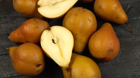 Whole fresh Bosc pears and halved of pear are on a wooden board Vídeo Stock 319960771