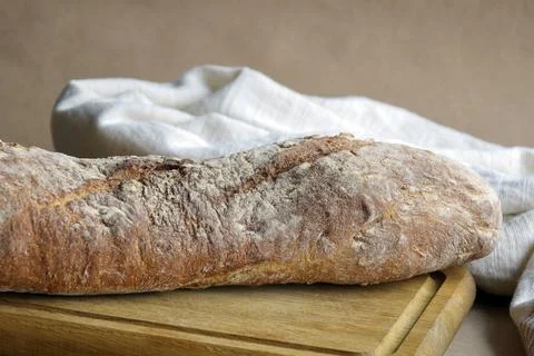 Whole fresh loaf of bread isolated on wooden cutting board Stock-Fotos