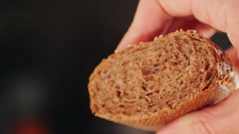 Whole grain bread close-up macro texture in hands. Man cutting fresh bread with 库存影片 236483166