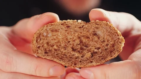 Whole grain bread close-up macro texture in hands. Man cutting fresh bread with Stock Footage 241754505