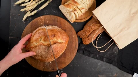 Whole grain bread lies on a kitchen wooden board with a chef Stock Footage 235676944