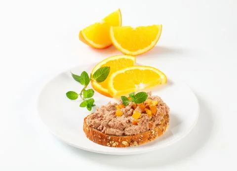 Whole grain bread with meat spread and pieces of candied orange rind Stock Photos
