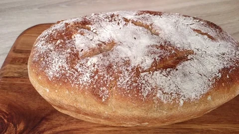 Whole grain bread put on kitchen wood plate by the chef in bakery. Fresh bread Stock Footage 252145786
