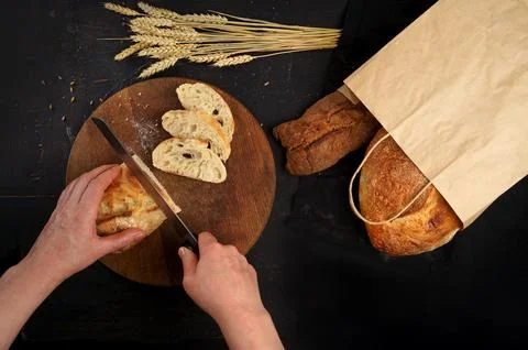 Whole grain bread put on kitchen wood plate with a chef holding knife for cut Stock Photos