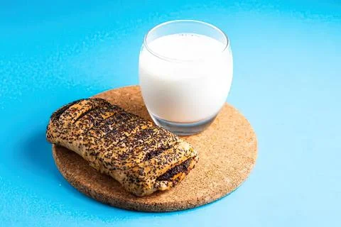 Whole grain bread slice with glass of milk on blue background Stock Photos