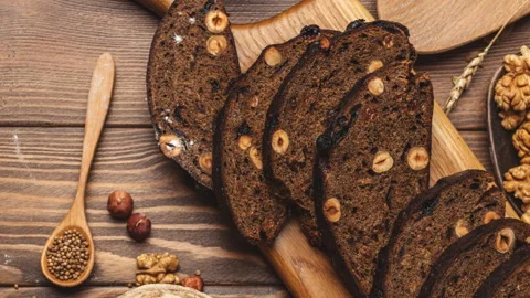 Whole grain multigrain bread, whole and sliced, contains seeds isolated on black Stock Footage 101436413