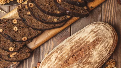 Whole grain multigrain bread, whole and sliced, contains seeds isolated on black Stock Footage 101436819