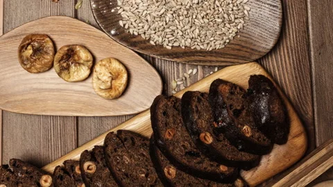 Whole grain multigrain bread, whole and sliced, contains seeds isolated on black Stock Footage 101438088