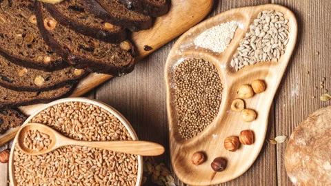 Whole grain multigrain bread, whole and sliced, contains seeds isolated on black Stock Footage 101440156