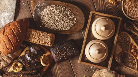 Whole grain multigrain bread, whole and sliced, contains seeds isolated on black Stock Footage 101441734