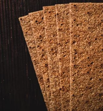 Whole grain rye crispbread crackers stacked on a rustic wooden background, .. Stock Photos