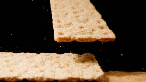 Whole grain slice falls on a heap slices on the table. Slow motion. Stock Footage 148468140