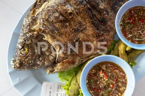 A Whole Grilled Fish With Chilli Sauce On Plate With A Receipt, Thailand