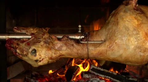 Whole lamb roasting on a spit in an open outdoor oven - tracking Stock Footage 40101297
