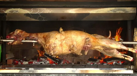 Whole Lamb Roasting on spit over fire - looping Stock Footage 40101266