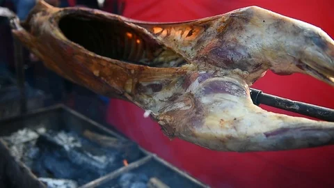 Whole lamb roasting on a spit over charcoal barbecue 库存影片 91868149