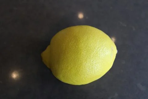 A whole lemon on a gray surface Stock Photos